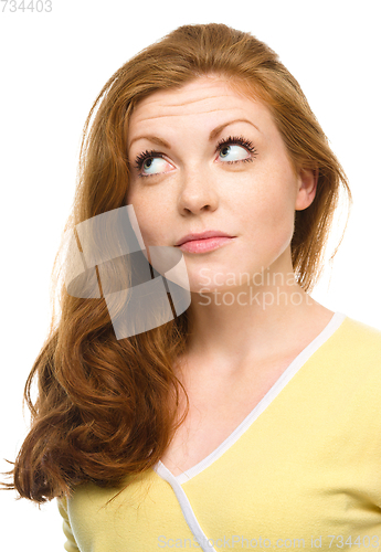 Image of Young happy woman is looking up and smile