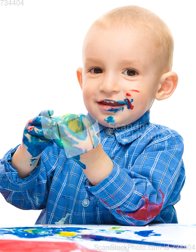 Image of Little boy is playing with paints