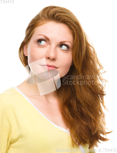 Image of Young happy woman is looking up and smile