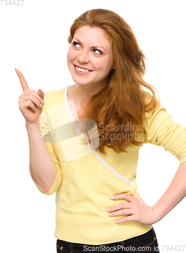 Image of Portrait of a young woman pointing to the left