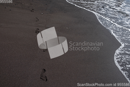 Image of foot prints on black sand