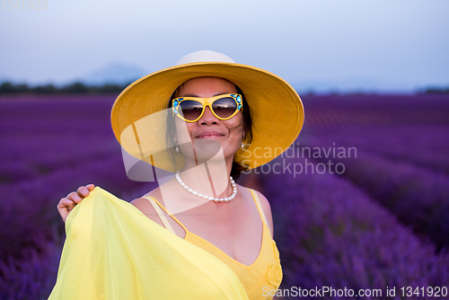 Image of asian woman in yellow dress and hat at lavender field