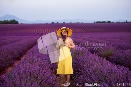 Image of asian woman in yellow dress and hat at lavender field