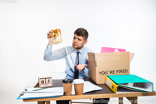 Image of The young man is resigned and folds things in the workplace