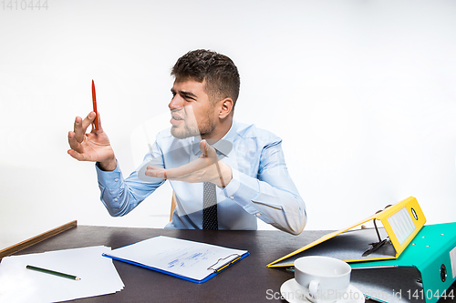 Image of The ink in the pen ended abruptly and the man is forced to write in pencil