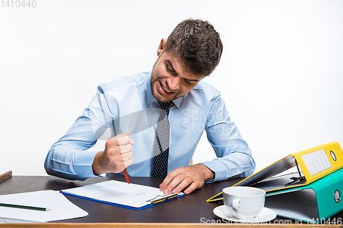 Image of The ink in the pen ended abruptly and the man is forced to write in pencil