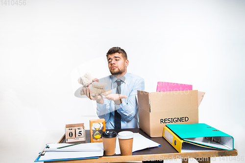 Image of The young man is resigned and folds things in the workplace