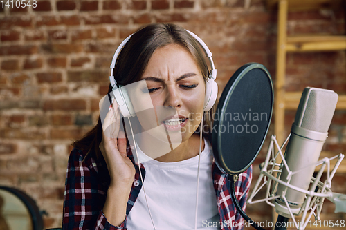 Image of Woman recording music, broadcasting and singing at home