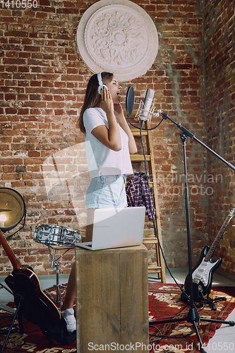 Image of Woman recording music, broadcasting and singing at home