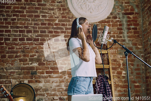 Image of Woman recording music, broadcasting and singing at home