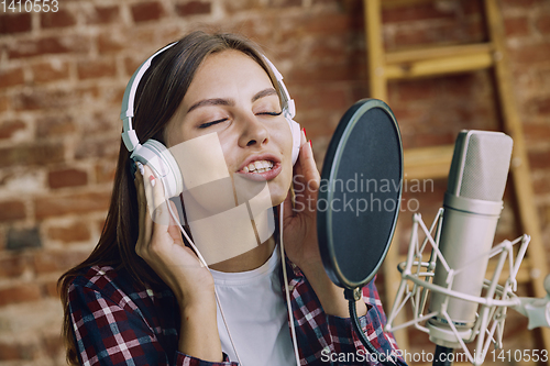 Image of Woman recording music, broadcasting and singing at home