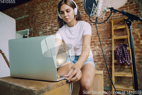 Image of Woman recording music, broadcasting and singing at home