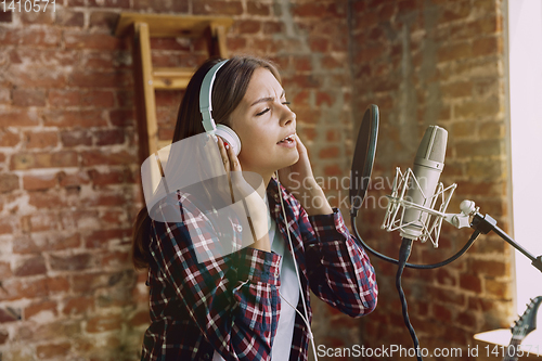 Image of Woman recording music, broadcasting and singing at home