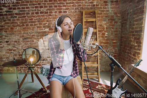 Image of Woman recording music, broadcasting and singing at home