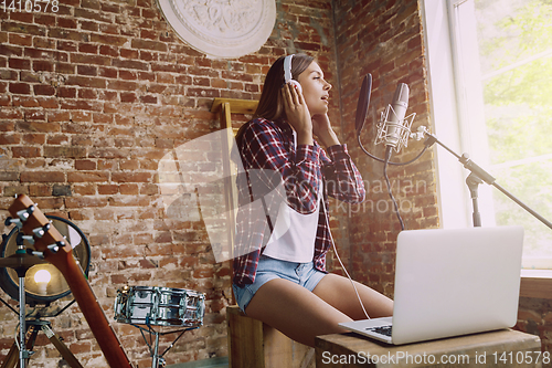 Image of Woman recording music, broadcasting and singing at home