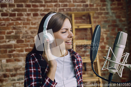 Image of Woman recording music, broadcasting and singing at home