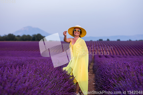 Image of asian woman in yellow dress and hat at lavender field