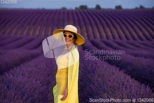 Image of asian woman in yellow dress and hat at lavender field