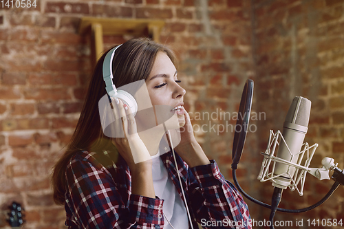 Image of Woman recording music, broadcasting and singing at home