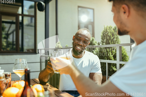 Image of Young men drinking beer and celebrating together