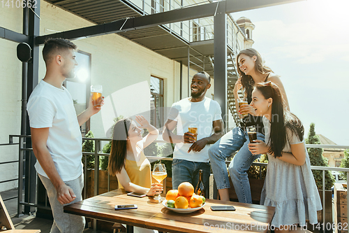 Image of Young group of friends drinking beer and celebrating together