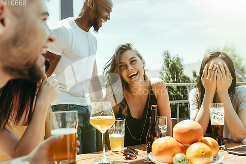 Image of Young group of friends drinking beer and celebrating together