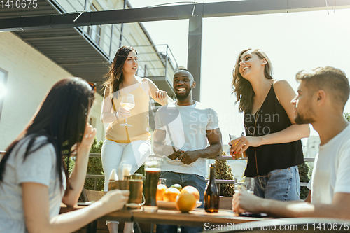 Image of Young group of friends drinking beer and celebrating together