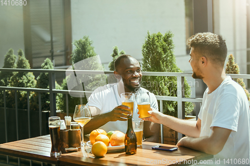 Image of Young men drinking beer and celebrating together