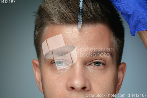 Image of Close-up portrait of young man isolated on grey studio background