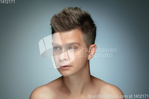 Image of Portrait of shirtless young man isolated on grey studio background