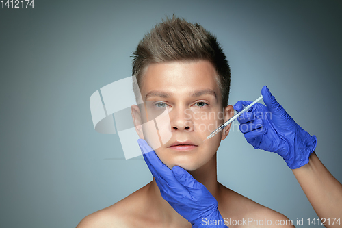 Image of Close-up portrait of young man isolated on grey studio background