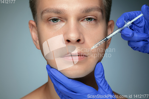 Image of Close-up portrait of young man isolated on grey studio background