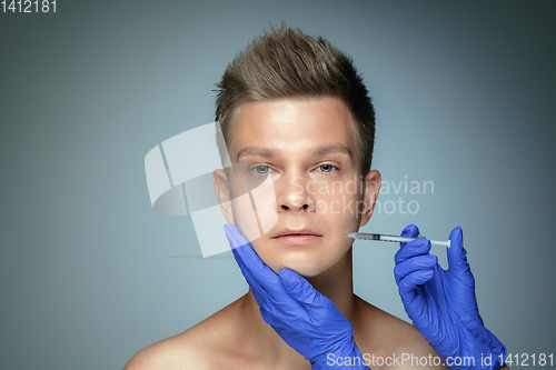 Image of Close-up portrait of young man isolated on grey studio background