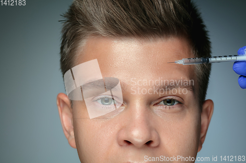 Image of Close-up portrait of young man isolated on grey studio background