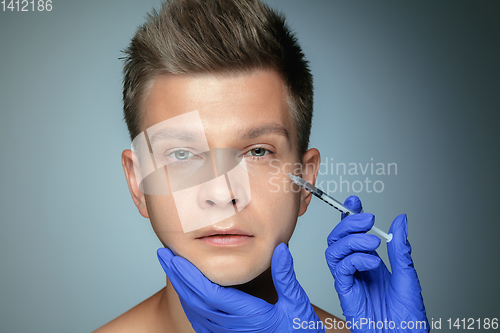 Image of Close-up portrait of young man isolated on grey studio background