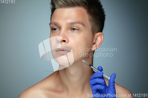 Image of Close-up portrait of young man isolated on grey studio background