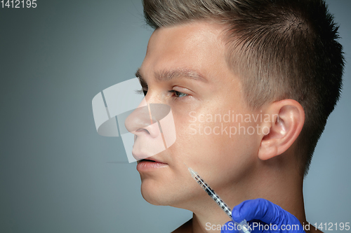 Image of Close-up portrait of young man isolated on grey studio background