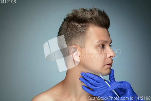 Image of Close-up portrait of young man isolated on grey studio background