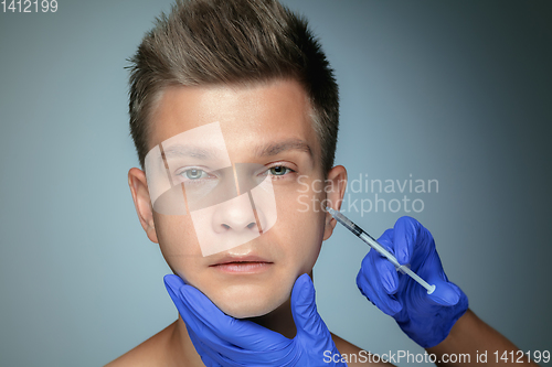 Image of Close-up portrait of young man isolated on grey studio background
