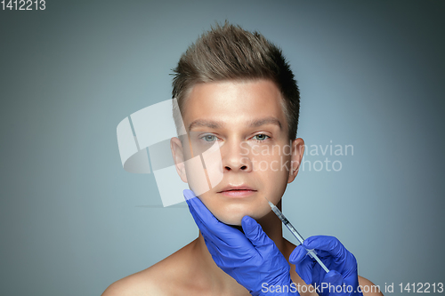 Image of Close-up portrait of young man isolated on grey studio background