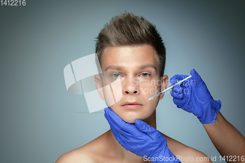 Image of Close-up portrait of young man isolated on grey studio background