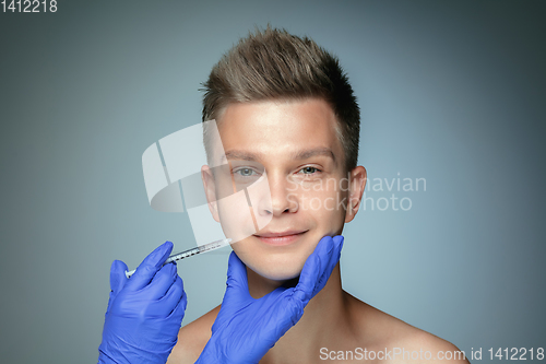 Image of Close-up portrait of young man isolated on grey studio background
