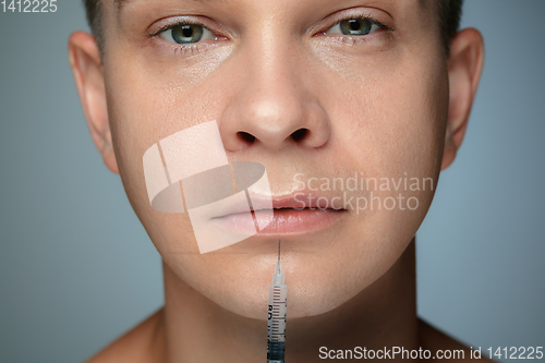 Image of Close-up portrait of young man isolated on grey studio background