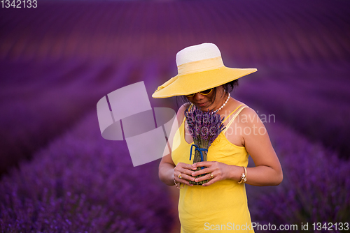 Image of asian woman in yellow dress and hat at lavender field