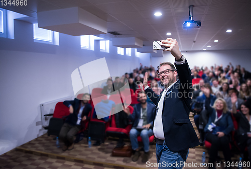 Image of businessman taking selfie at conference room