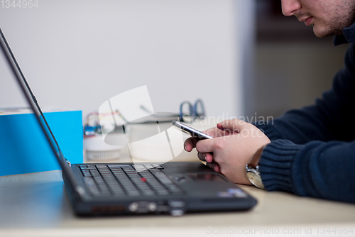 Image of Young casual businessman using smartphone