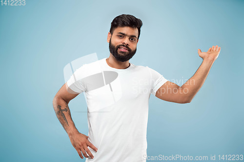 Image of Half-length close up portrait of young man on blue background.