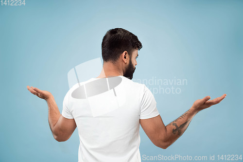 Image of Half-length close up portrait of young man on blue background.