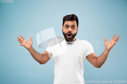 Image of Half-length close up portrait of young man on blue background.