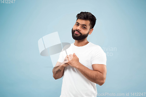 Image of Half-length close up portrait of young man on blue background.